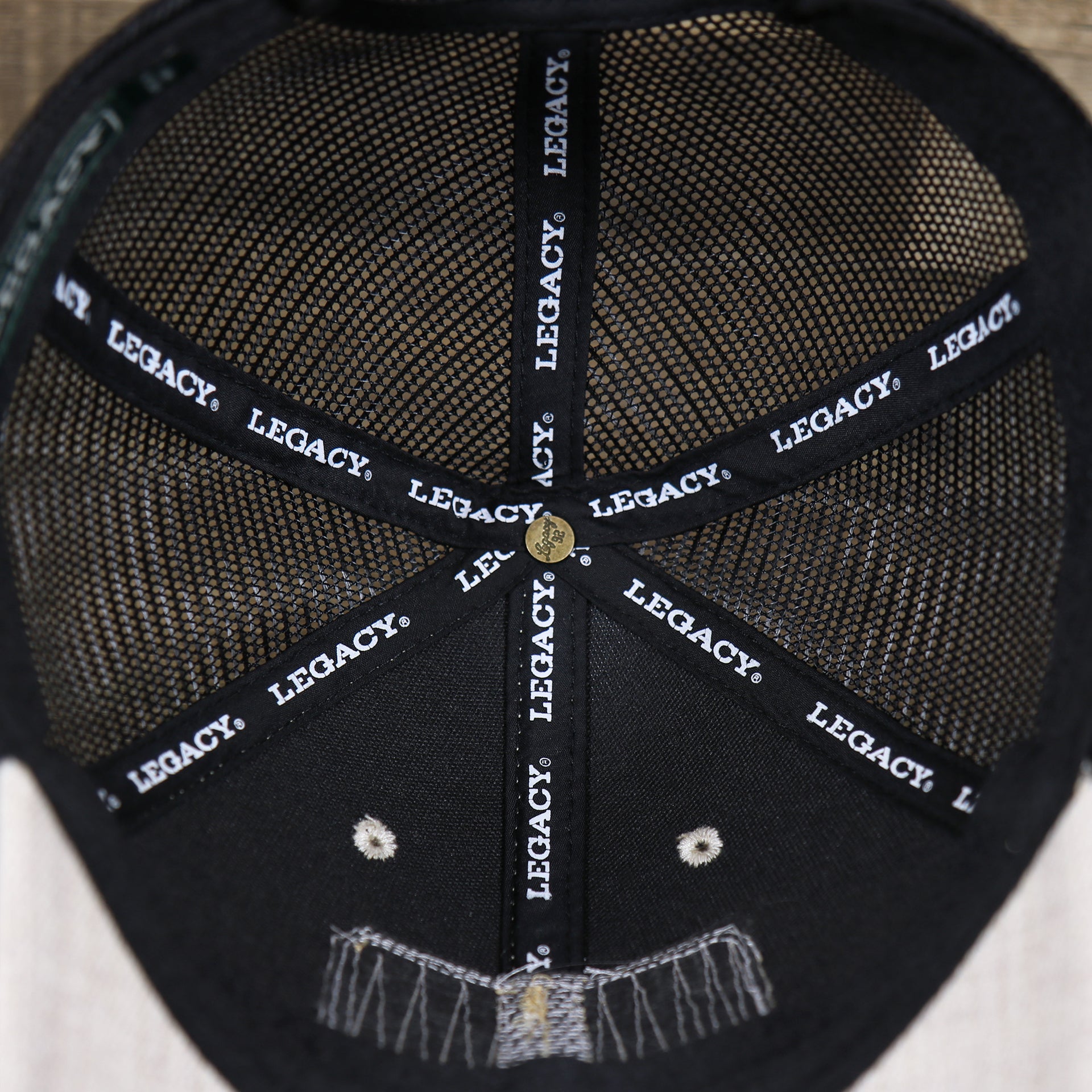 The inside of the New Jersey Ocean City Sunset Mesh Back Trucker Hat | Heather Tan And Black Mesh Trucker Hat