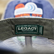 The Legacy Tag on the OCNJ 1879 Ocean City New Jersey Wave Denim Inspired Trucker Hat | Navy And Khaki Mesh Trucker Hat