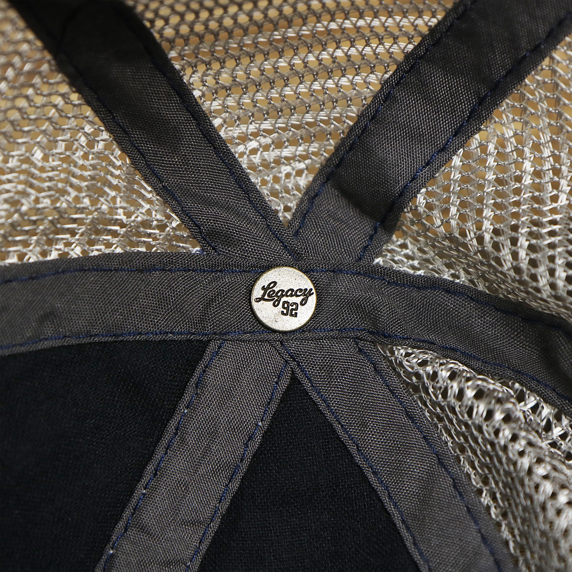 The Legacy Engraved Button on the OCNJ 1879 Ocean City New Jersey Wave Denim Inspired Trucker Hat | Navy And Khaki Mesh Trucker Hat