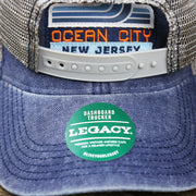 The Legacy Sticker on the OCNJ 1879 Ocean City New Jersey Wave Denim Inspired Trucker Hat | Navy And Khaki Mesh Trucker Hat