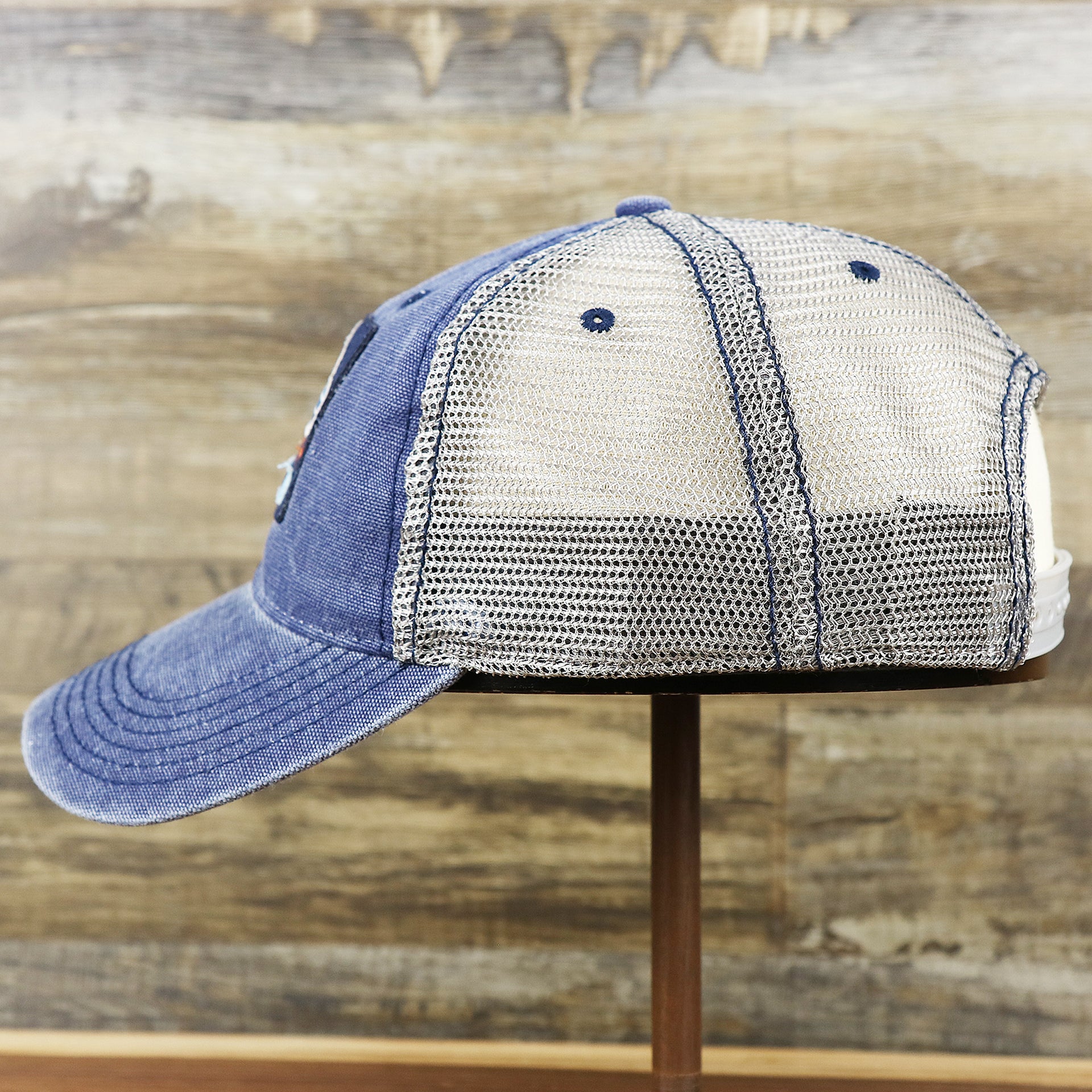 The wearer's left on the OCNJ 1879 Ocean City New Jersey Wave Denim Inspired Trucker Hat | Navy And Khaki Mesh Trucker Hat