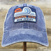 The front of the OCNJ 1879 Ocean City New Jersey Wave Denim Inspired Trucker Hat | Navy And Khaki Mesh Trucker Hat