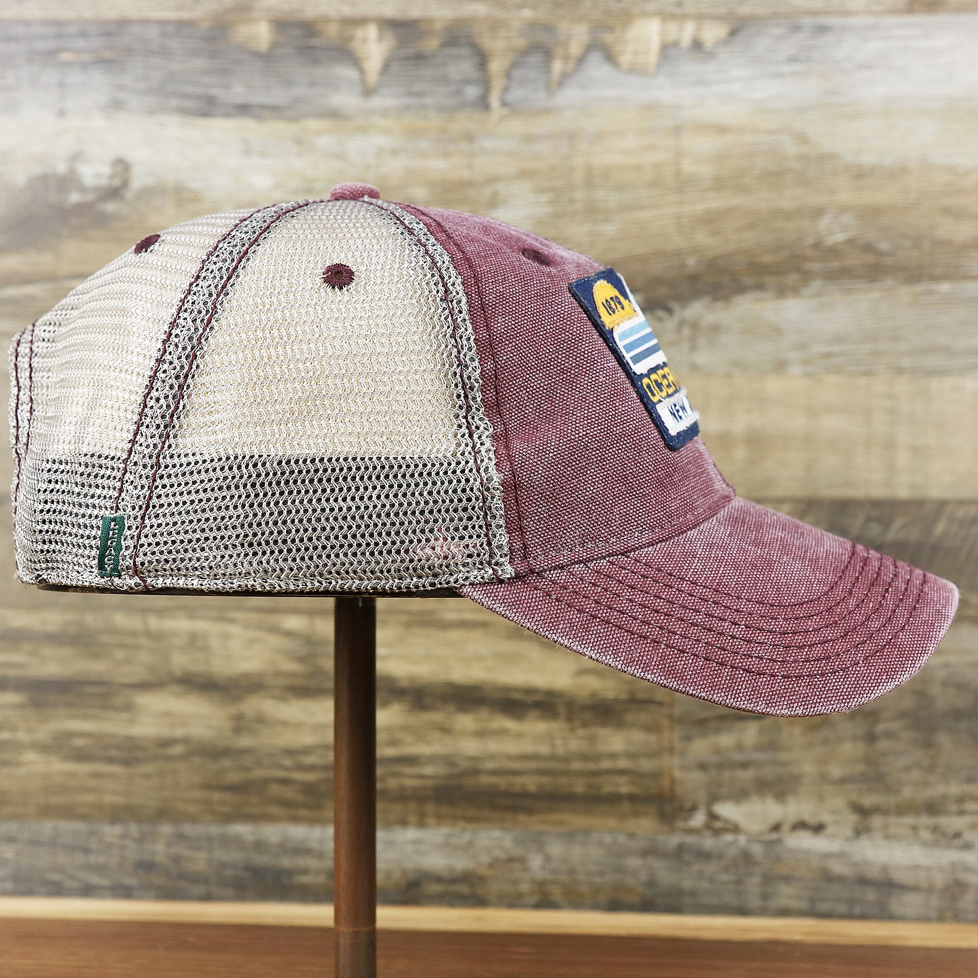 The wearer's right on the OCNJ 1879 Ocean City New Jersey Wave Trucker Hat | Burgundy And Khaki Mesh Trucker Hat