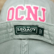 The Legacy Tag on the Pink OCNJ Wordmark White Outline Dad Hat | Sawgrass Dad Hat
