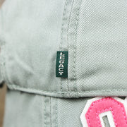 The Green Legacy Tag on the Pink OCNJ Wordmark White Outline Dad Hat | Sawgrass Dad Hat