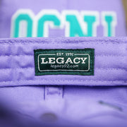 The Legacy Tag on the Teal OCNJ Double Wordmark White Outline Bucket Hat | Lavender Bucket Hat