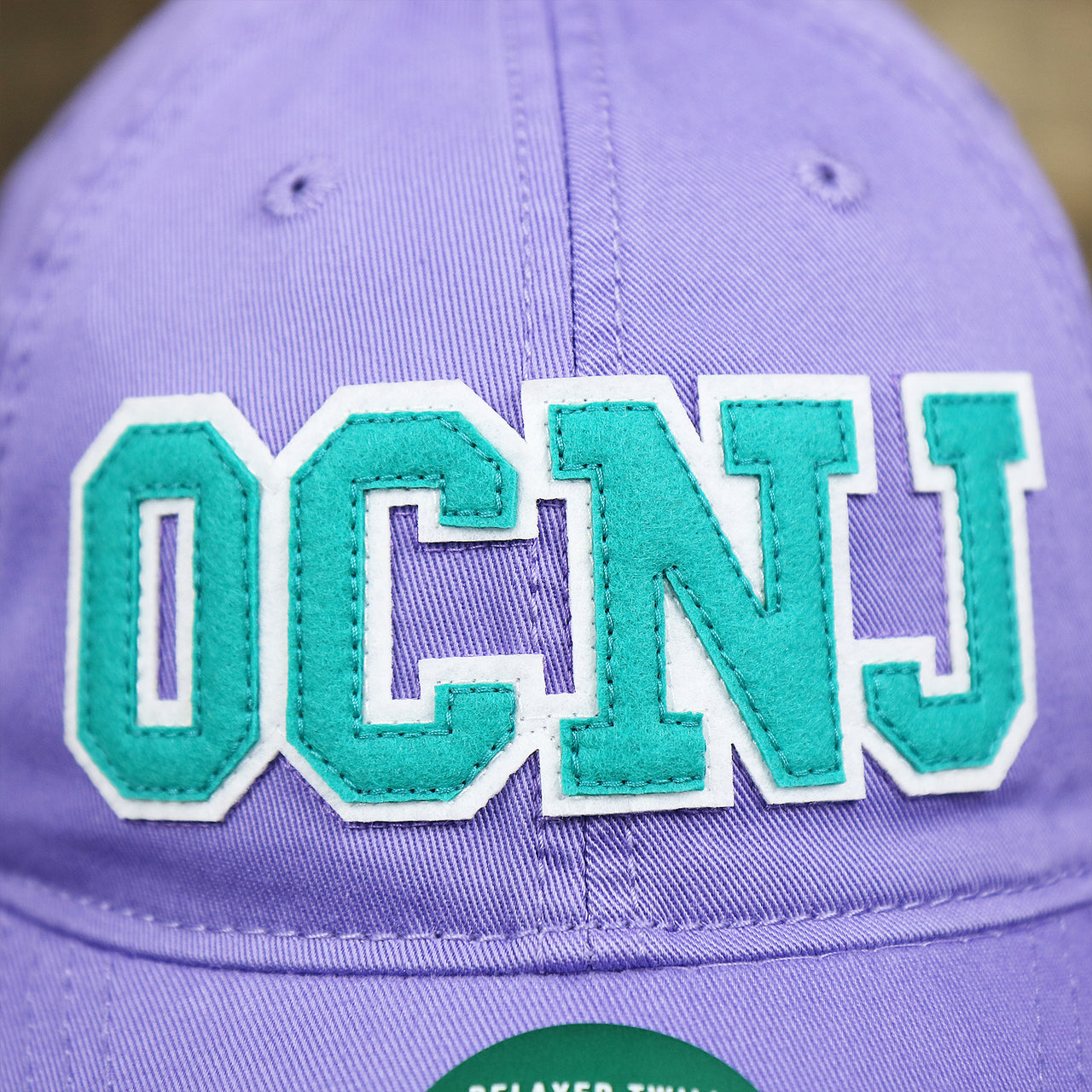 The OCNJ Wordmark on the Teal OCNJ Double Wordmark White Outline Bucket Hat | Lavender Bucket Hat
