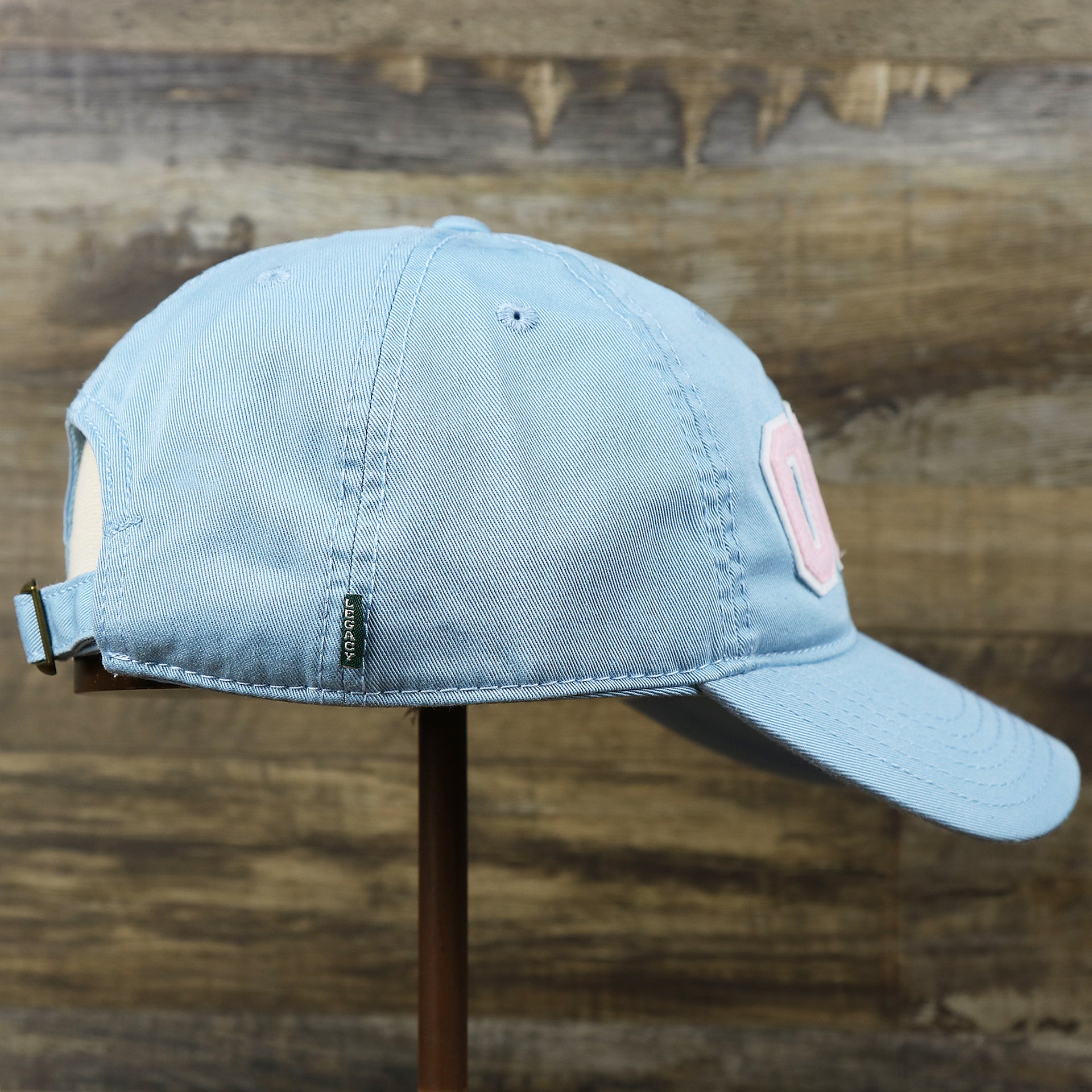 The wearer's right on the Youth Pink OCNJ Wordmark White Outline Dad Hat | Youth Light Blue Dad Hat