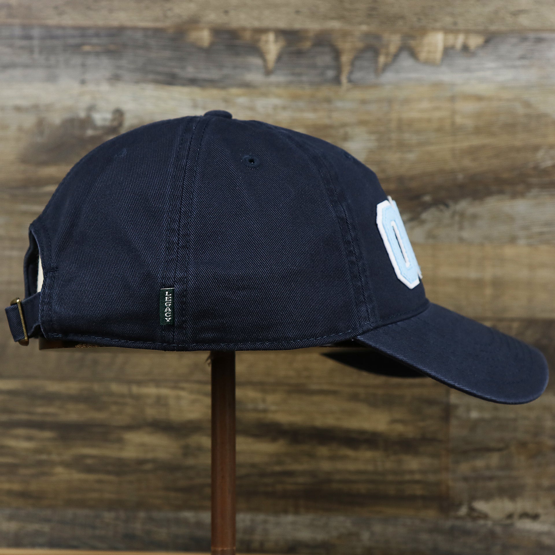 The wearer's right on the Light Blue OCNJ Wordmark White Outline Dad Hat | Navy Blue Dad Hat