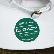 The Legacy Sticker on the Light Blue OCNJ Wordmark Pink Outline Dad Hat | White Dad Hat