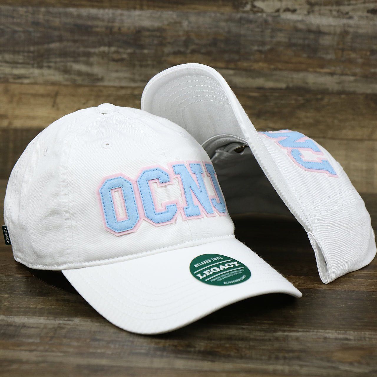 The Light Blue OCNJ Wordmark Pink Outline Dad Hat | White Dad Hat