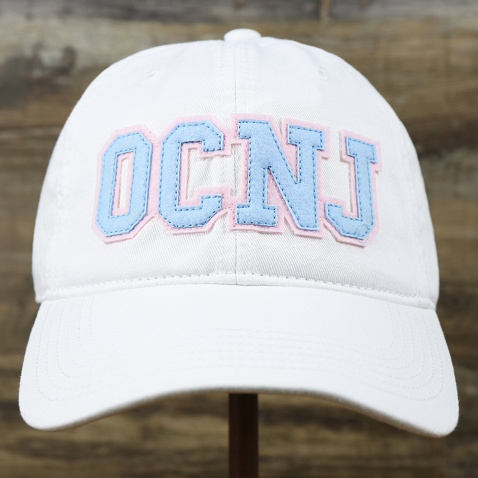 The front of the Light Blue OCNJ Wordmark Pink Outline Dad Hat | White Dad Hat