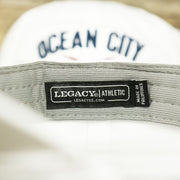 The Legacy Tag on the Ocean City New Jersey Wordmark Crossed Oars Logo Dad Hat | White Dad Hat