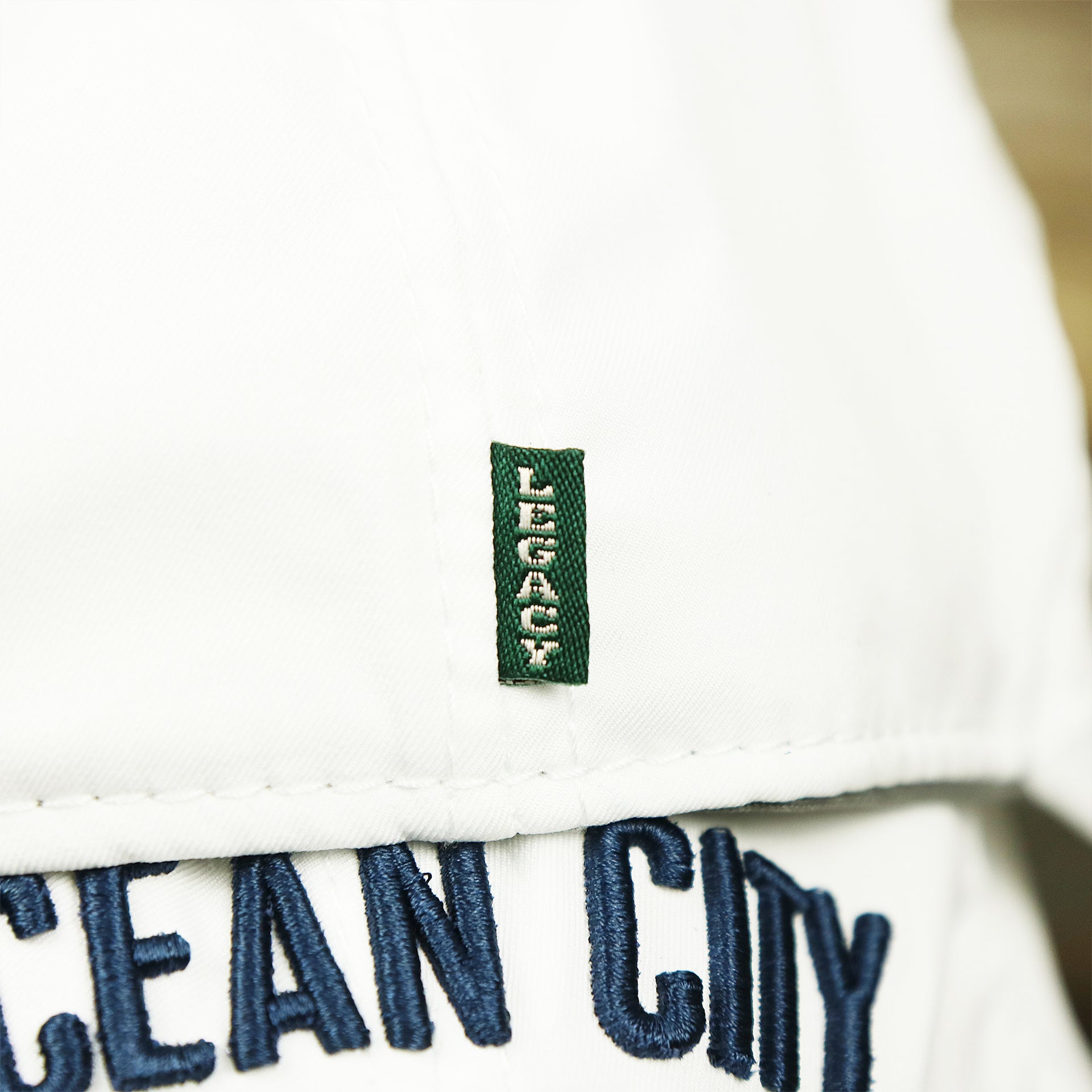 The green legacy tag on the Ocean City New Jersey Wordmark Crossed Oars Logo Dad Hat | White Dad Hat
