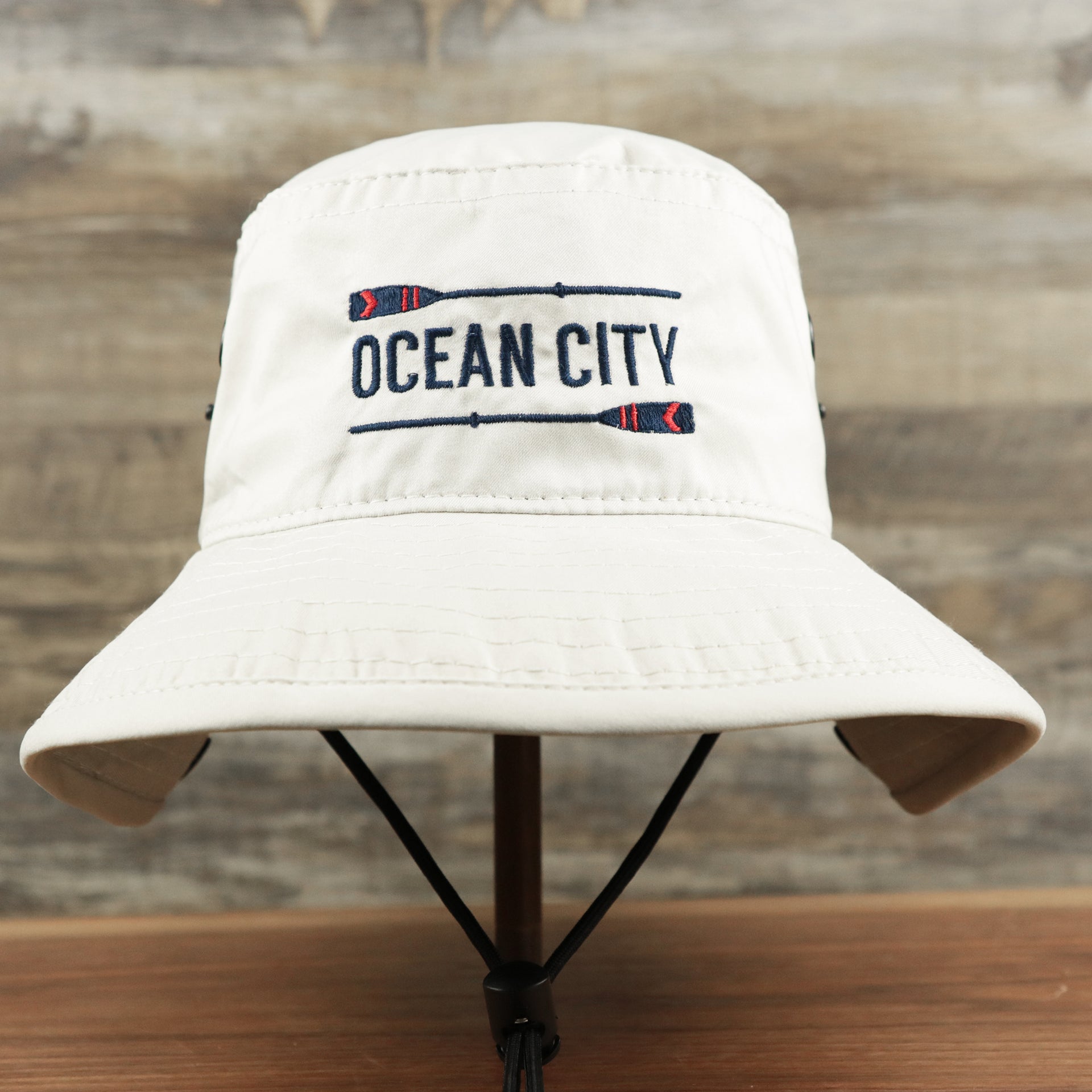 The front of the Ocean City Wordmark Parallel Oars New Jersey Bucket Hat | Stone Bucket Hat