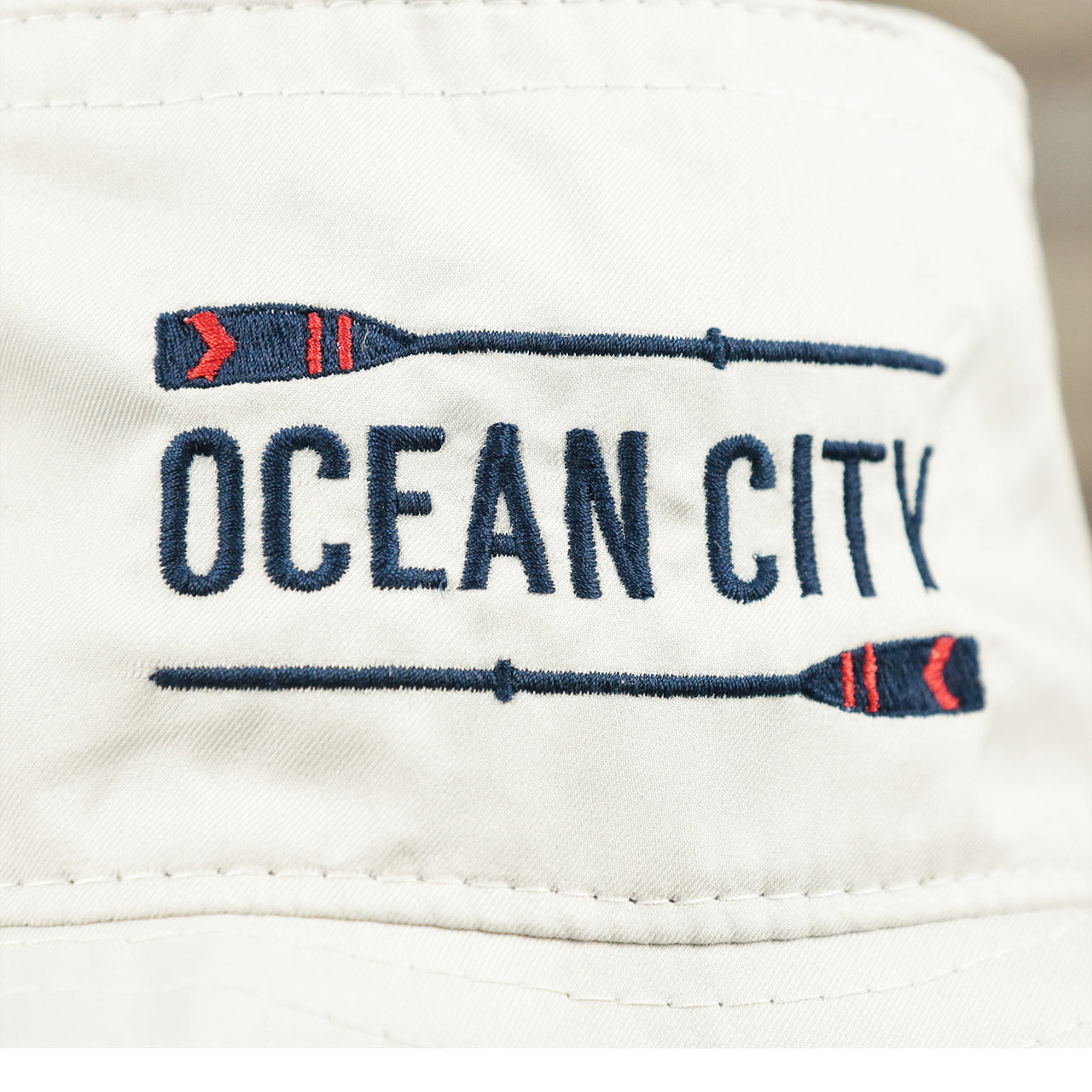 The Ocean City Wordmark on the Ocean City Wordmark Parallel Oars New Jersey Bucket Hat | Stone Bucket Hat