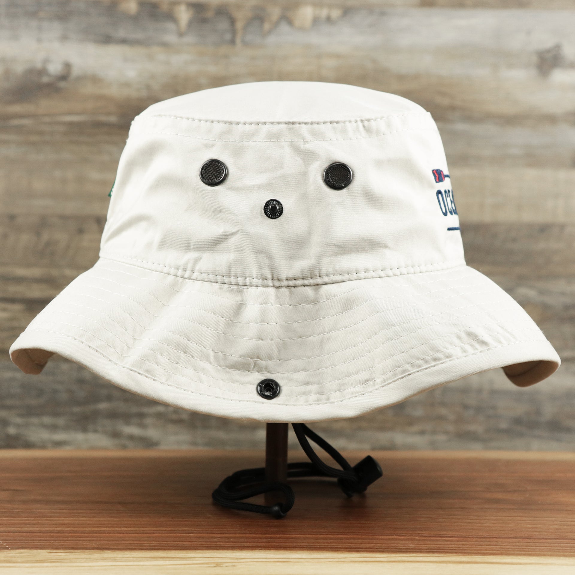 The wearer's right on the Ocean City Wordmark Parallel Oars New Jersey Bucket Hat | Stone Bucket Hat