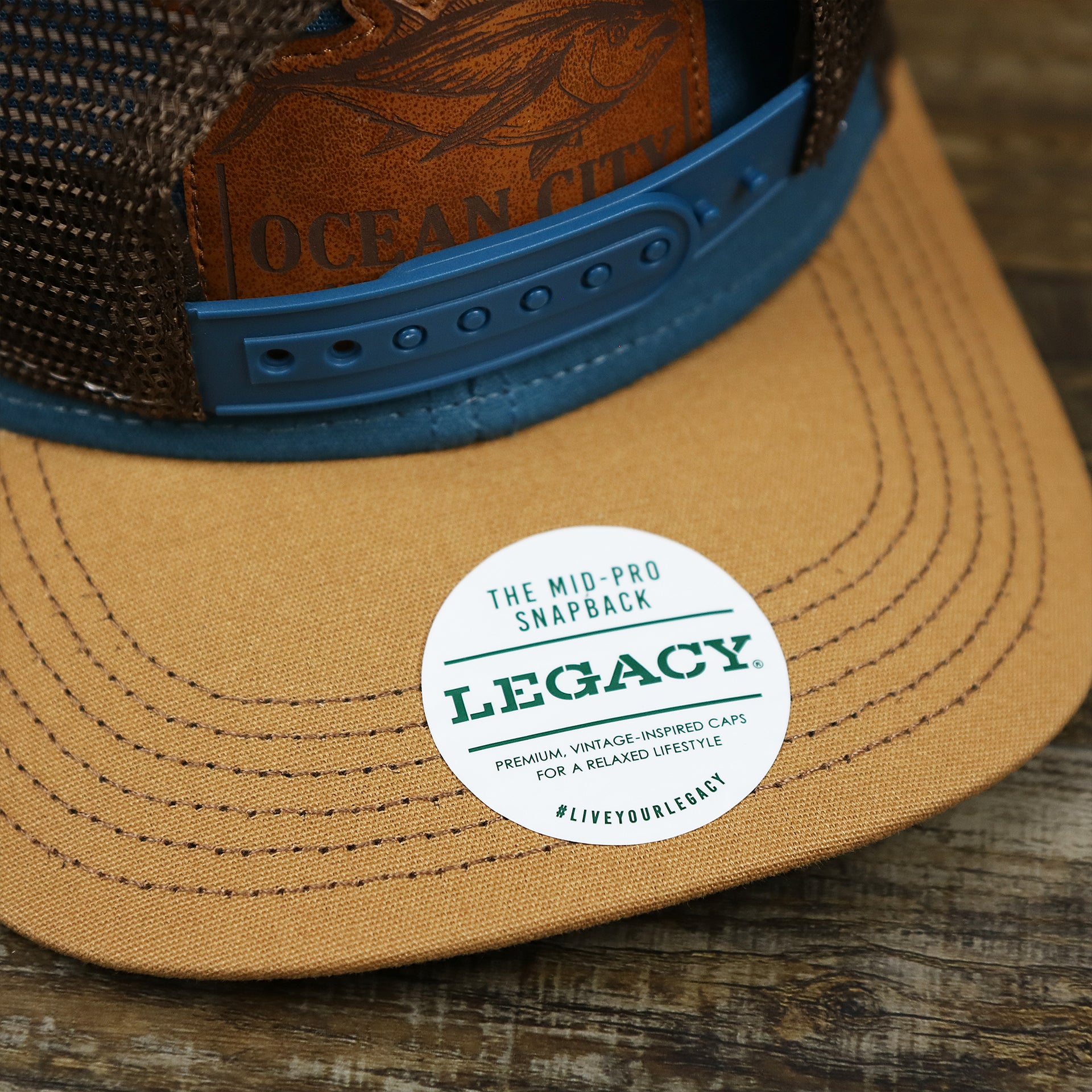 The Legacy Sticker on the Ocean City Leather Tuna Patch New Jersey Mesh Back Trucker Hat | Marine Blue Mesh Trucker Hat