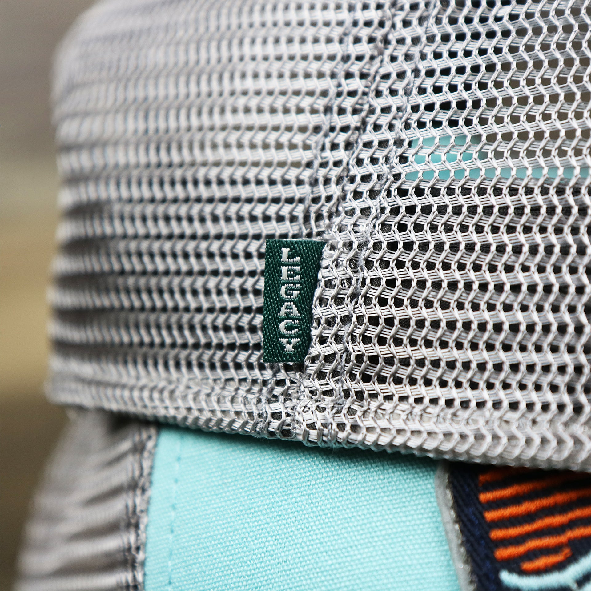 The Green Legacy Tag on the New Jersey Ocean City Sunset Mesh Back Trucker Hat | Tahiti Blue And Grey Mesh Trucker Hat