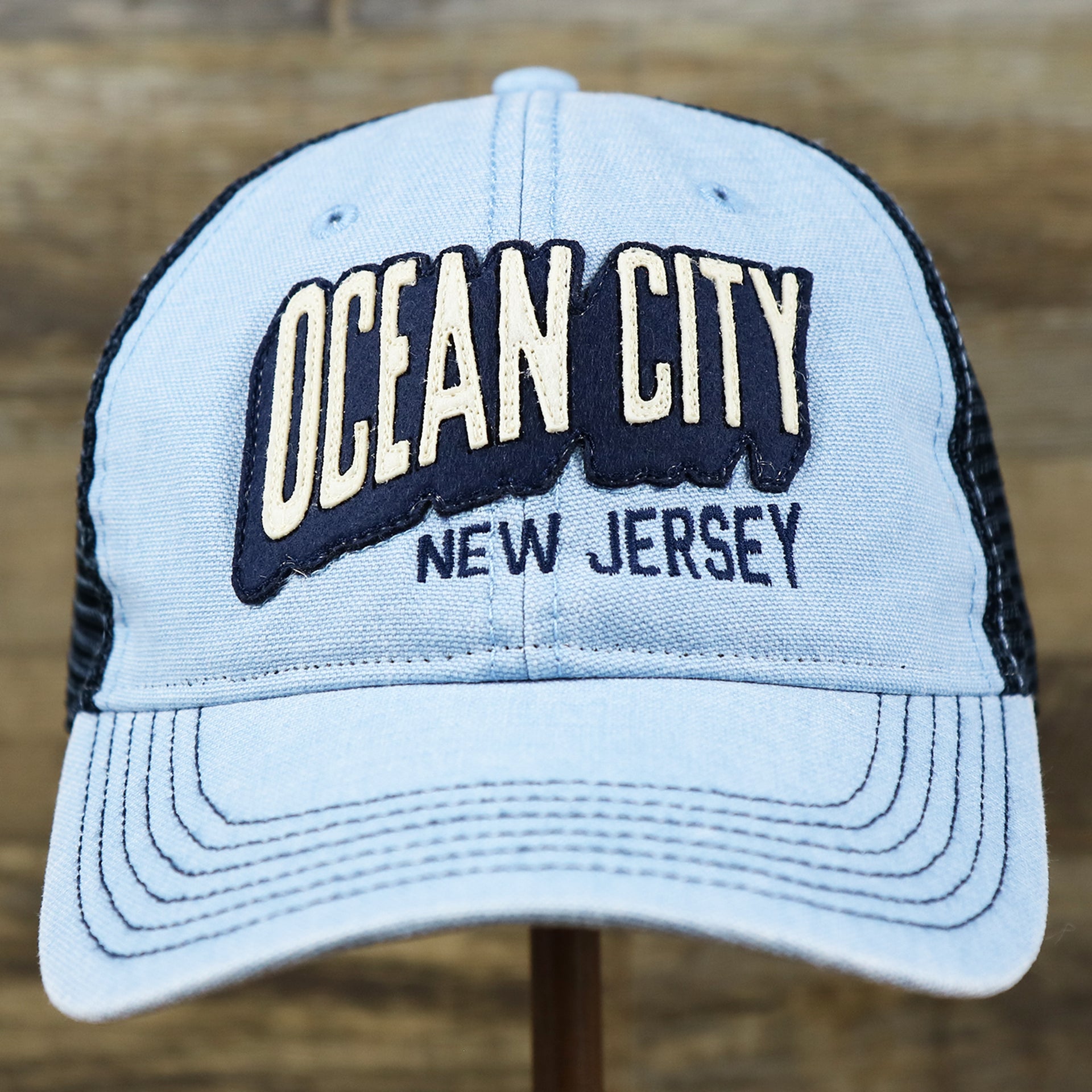 The front of the OCNJ Block Ocean City Wordmark Mesh Trucker Hat | Light Blue Trucker Hat