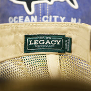 The Legacy Tag on the Ocean City Horizon Shark Vintage Mesh Back Worn Colorway Trucker Hat | Blue Trucker Hat