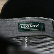 The Legacy Tag on the Youth New Jersey Ocean City Sunset Mesh Back Trucker Hat | Tahiti Blue And Grey Mesh Trucker Hat
