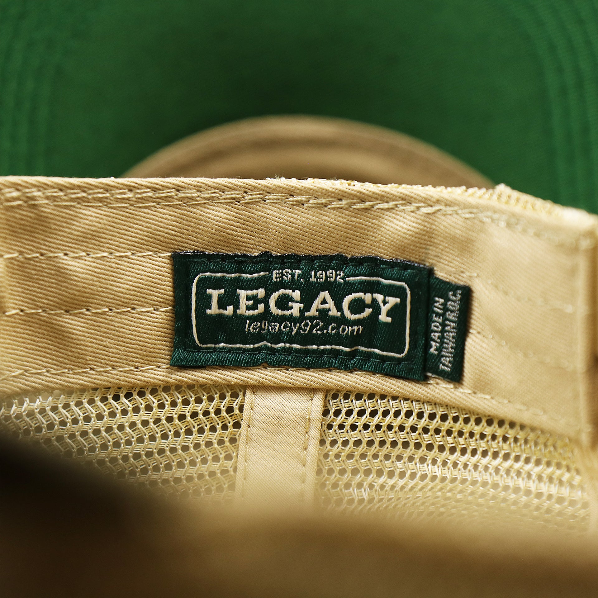 The Legacy Tag on the Ocean City New Jersey Since 1897 Helm Patch Camo Print Mesh Back Trucker Hat | Camo Green Trucker Hat