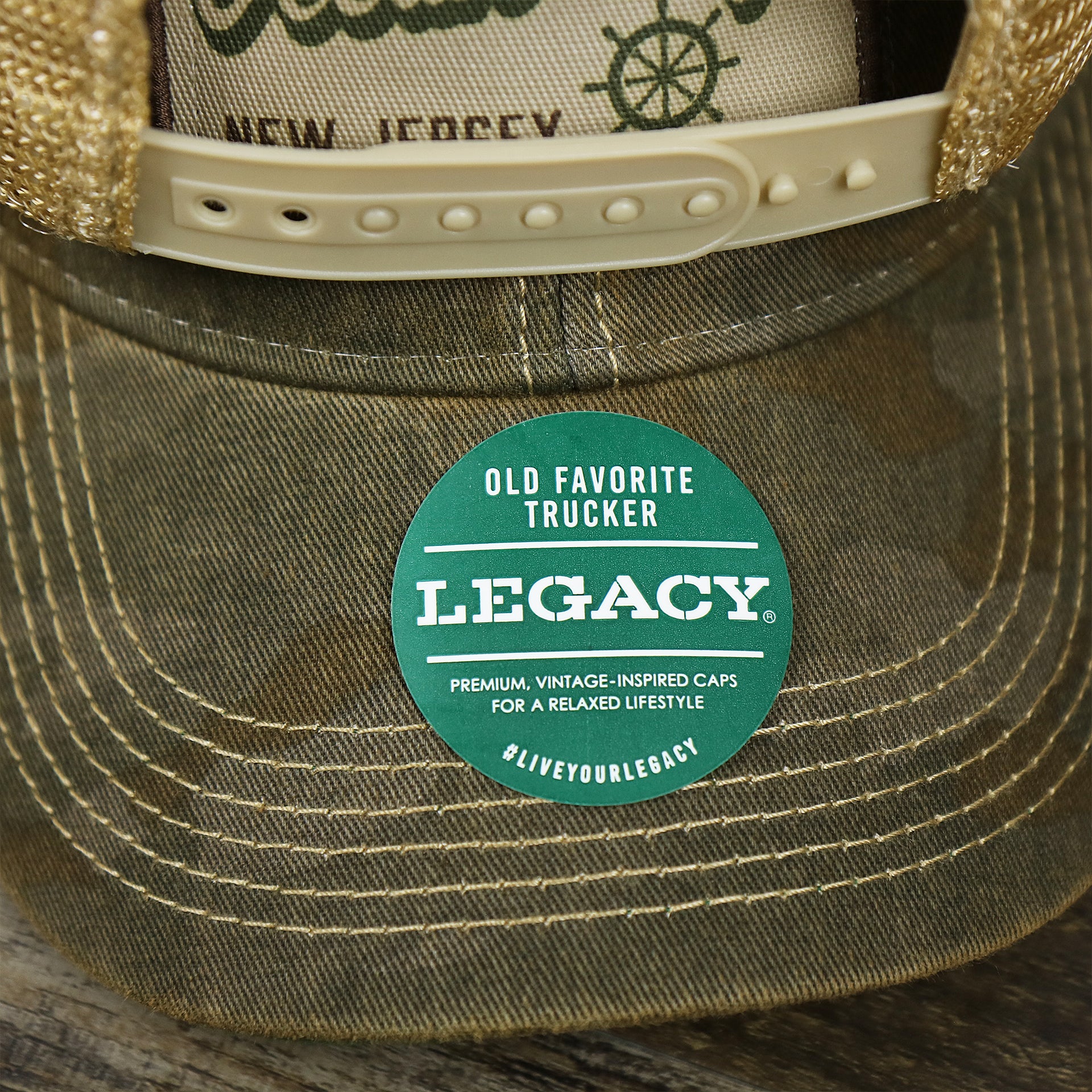 The Legacy Sticker on the Ocean City New Jersey Since 1897 Helm Patch Camo Print Mesh Back Trucker Hat | Camo Green Trucker Hat