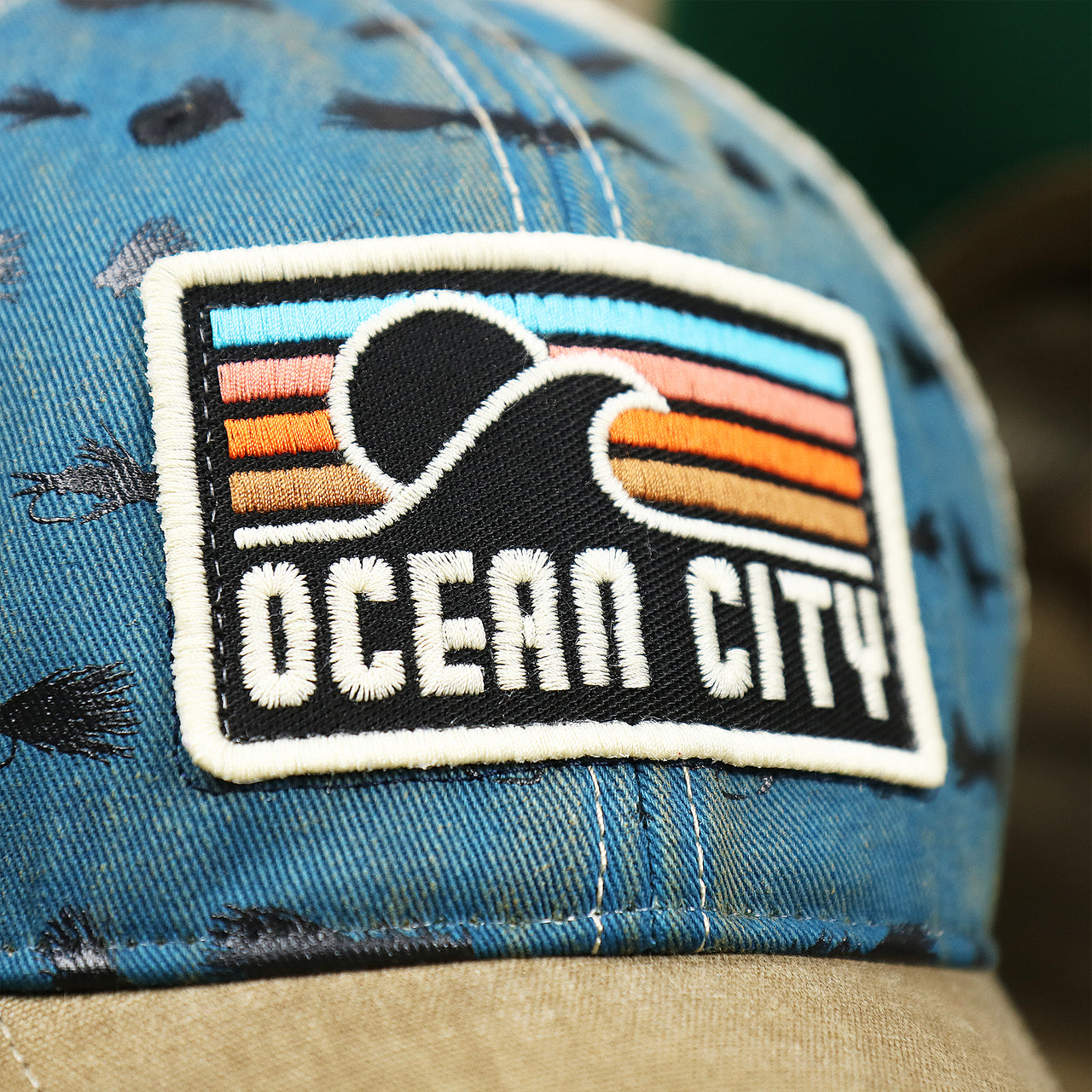 The OC Sunset Patch on the Ocean City Sunset Patch Fishing Lure Print Mesh Back Trucker Hat | Marine Blue Trucker Hat