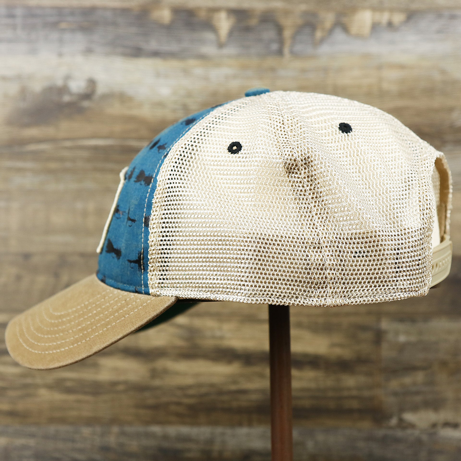 The wearer's left on the Ocean City Sunset Patch Fishing Lure Print Mesh Back Trucker Hat | Marine Blue Trucker Hat