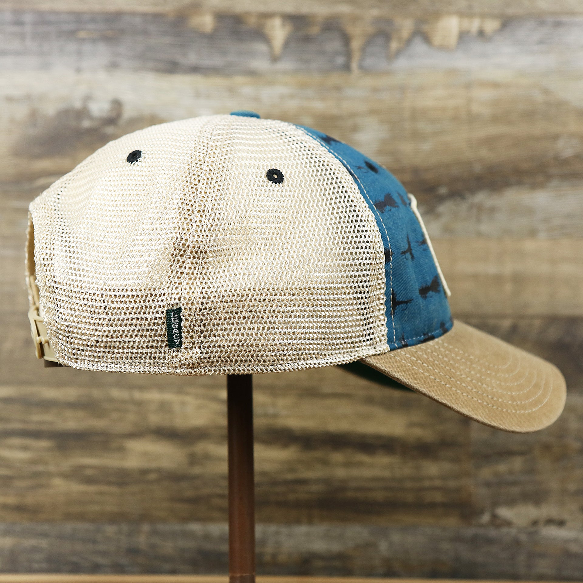 The wearer's right on the Ocean City Sunset Patch Fishing Lure Print Mesh Back Trucker Hat | Marine Blue Trucker Hat