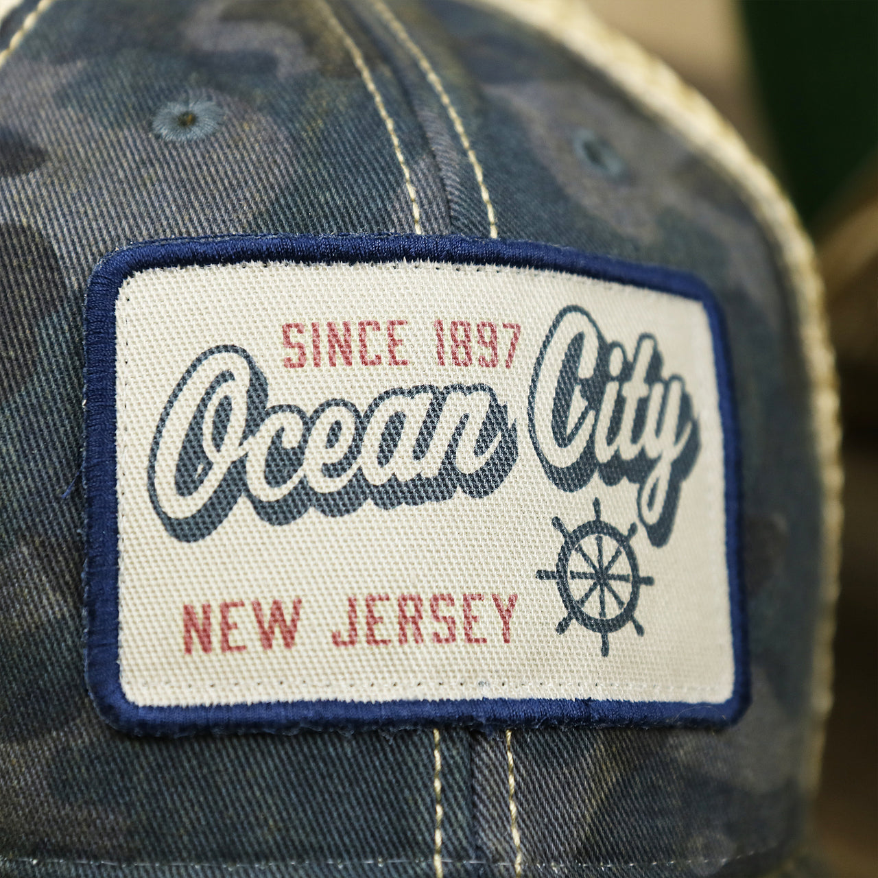 The Ocean City Patch on the Ocean City New Jersey Since 1897 Helm Patch Camo Print Mesh Back Trucker Hat | Camo Navy Blue Trucker Hat