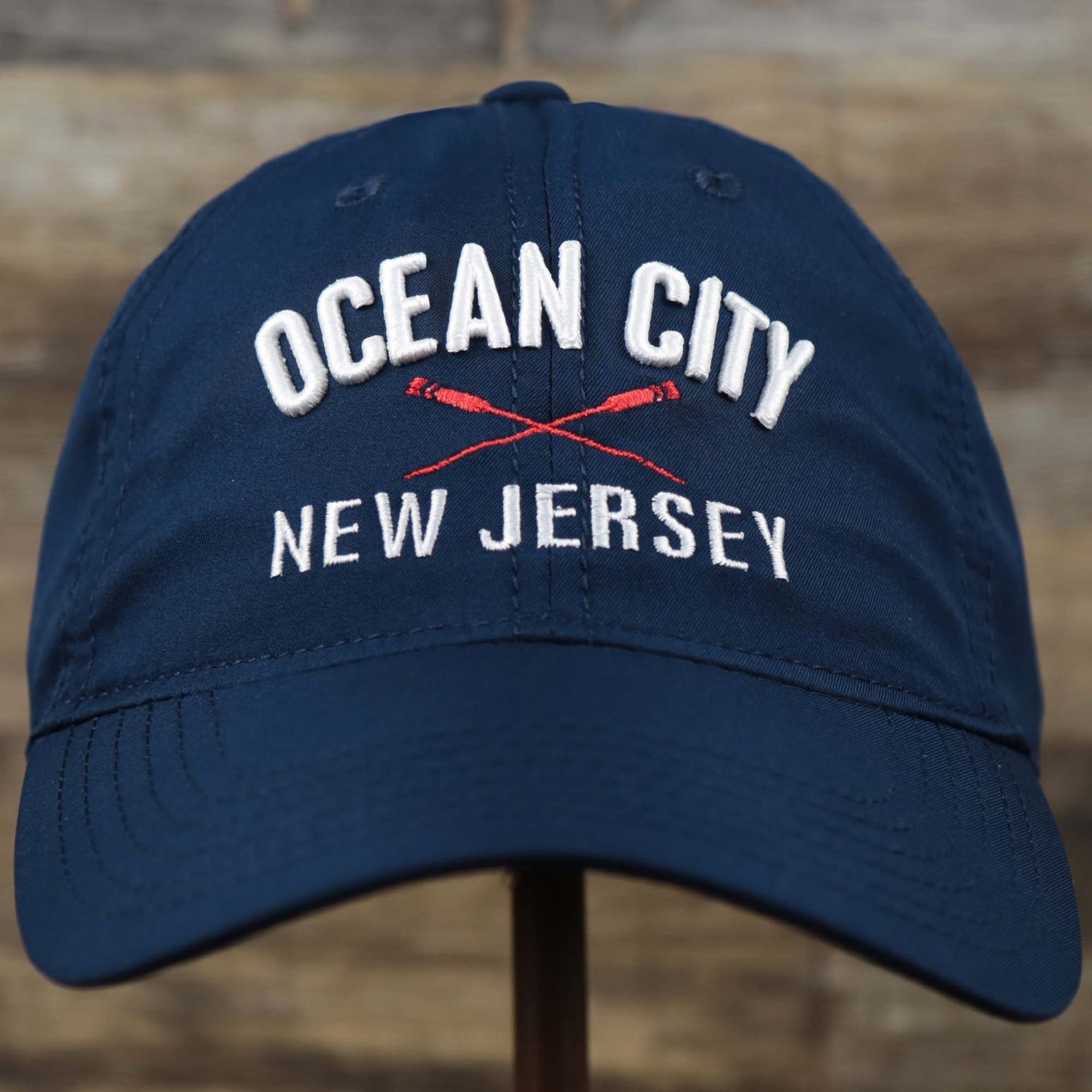 The front of the Ocean City New Jersey Wordmark Crossed Oars Logo Dad Hat | Navy Blue Dad Hat