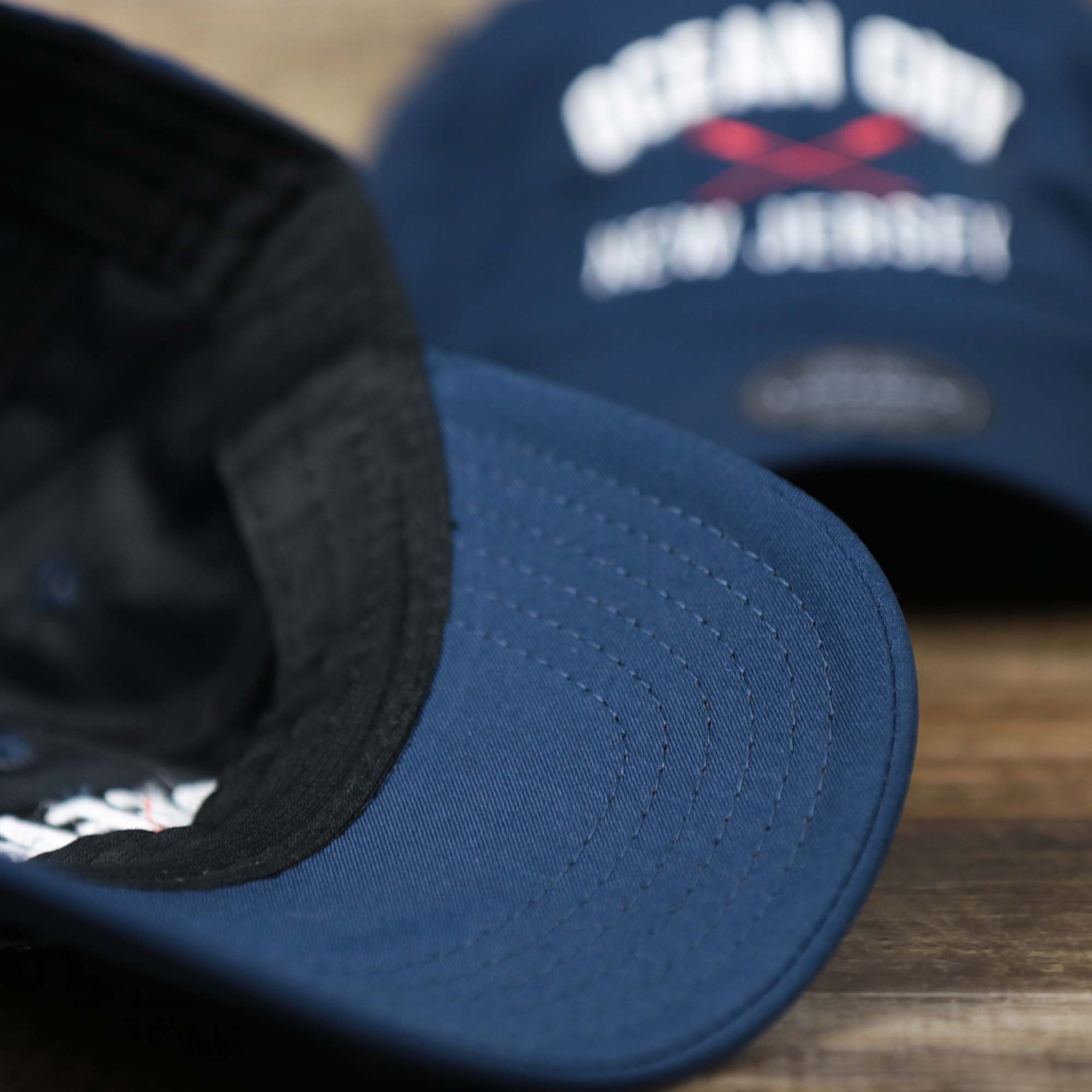 The navy undervisor on the Ocean City New Jersey Wordmark Crossed Oars Logo Dad Hat | Navy Blue Dad Hat
