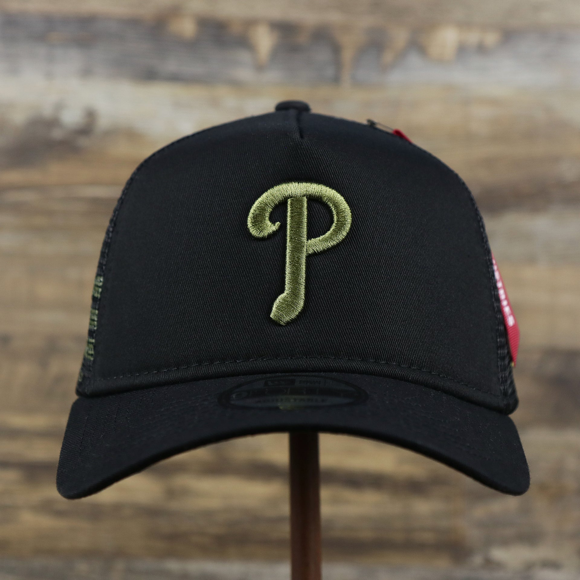 The front of the Philadelphia Phillies Alpha Industries Flying A Mesh Print 9Forty Trucker Hat With Flight Tag | Black Trucker Hat