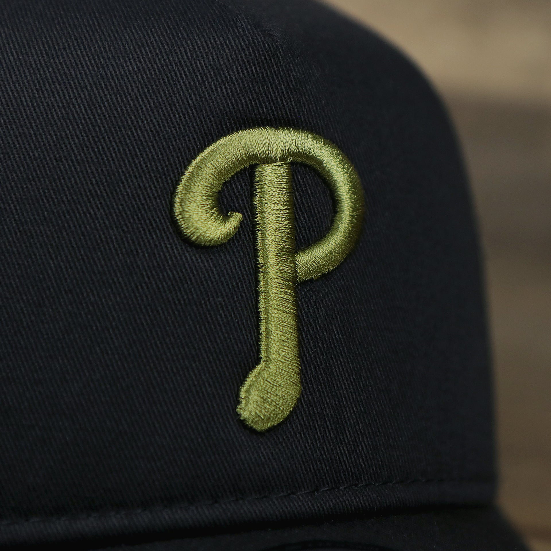 The Phillies Logo on the Philadelphia Phillies Alpha Industries Flying A Mesh Print 9Forty Trucker Hat With Flight Tag | Black Trucker Hat