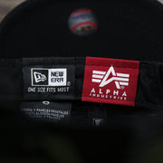 The New Era Tag and Alpha Industries Tag on the Philadelphia Phillies Alpha Industries Flying A Mesh Print 9Forty Trucker Hat With Flight Tag | Black Trucker Hat