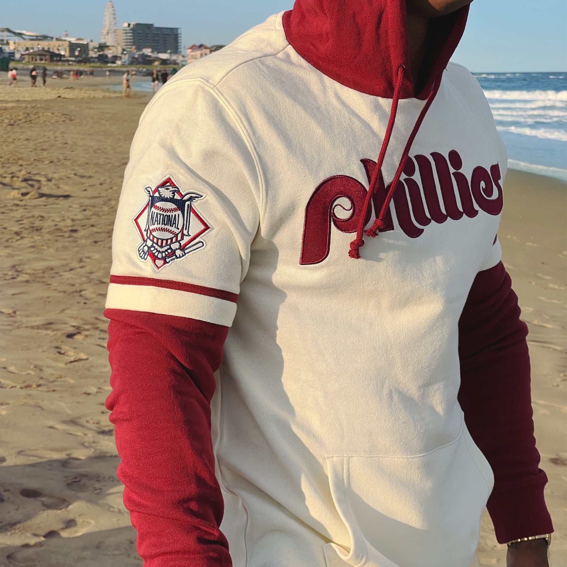 The National League Side Patch on the Cooperstown Philadelphia Phillies Wordmark Retro Phillies Colorway Trifecta Shortstop Layered Hoodie With MLB Side Patch | Cream And Maroon Pullover Hoodie