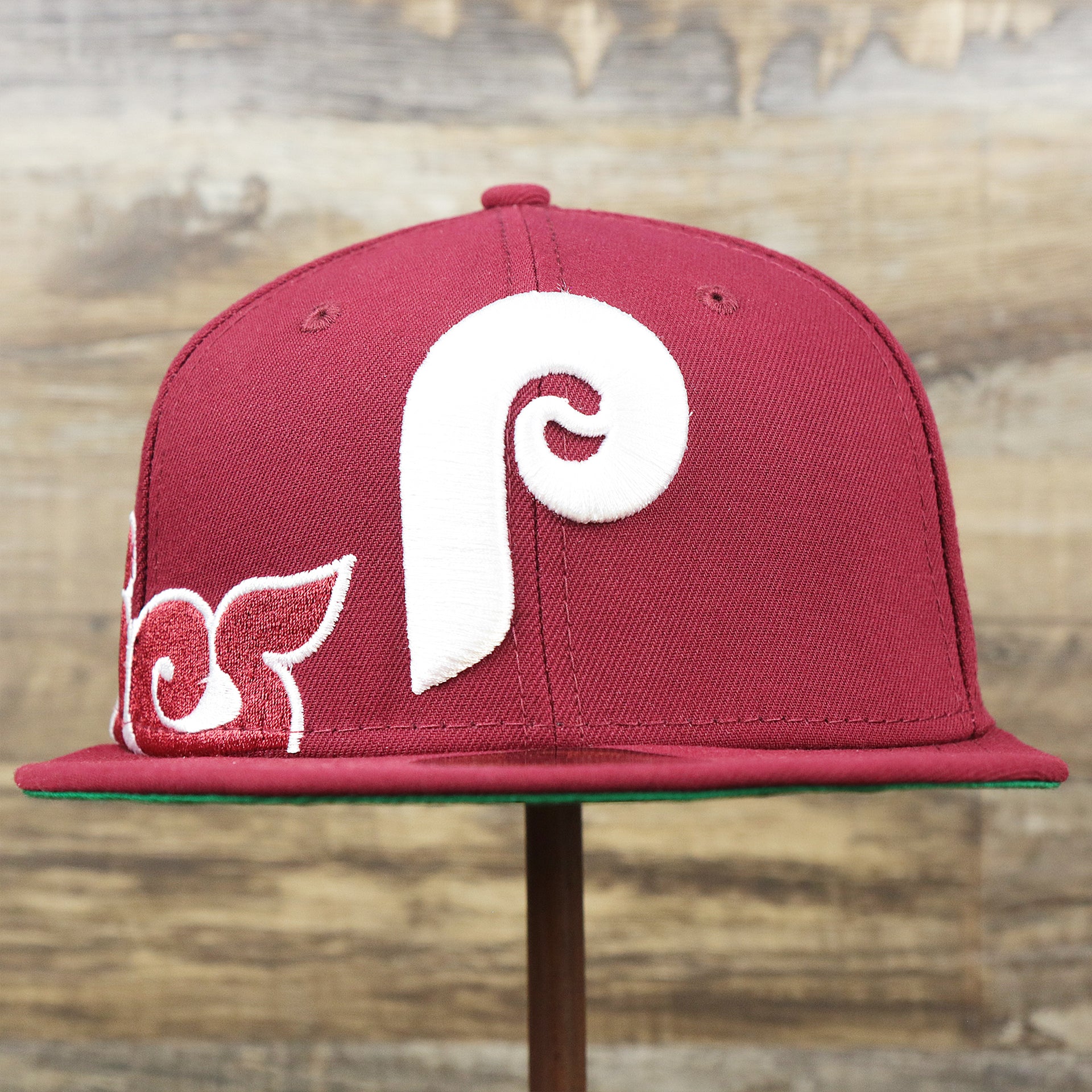 The front of the Cooperstown Philadelphia Phillies Wordmark Side Split Vintage Green Bottom With Phillies Embroidered Undervisor Fitted Cap | Maroon Blue 59Fifty Cap