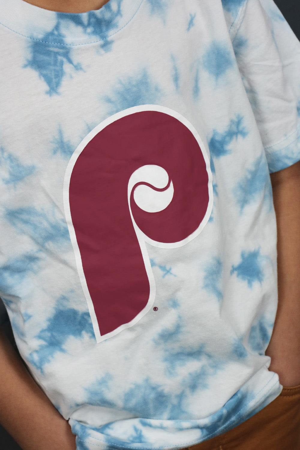A close up of the Phillies Cooperstown Logo on the Youth Philadelphia Phillies Cooperstown Tie Dye T-Shirt | New Era Sky Blue
