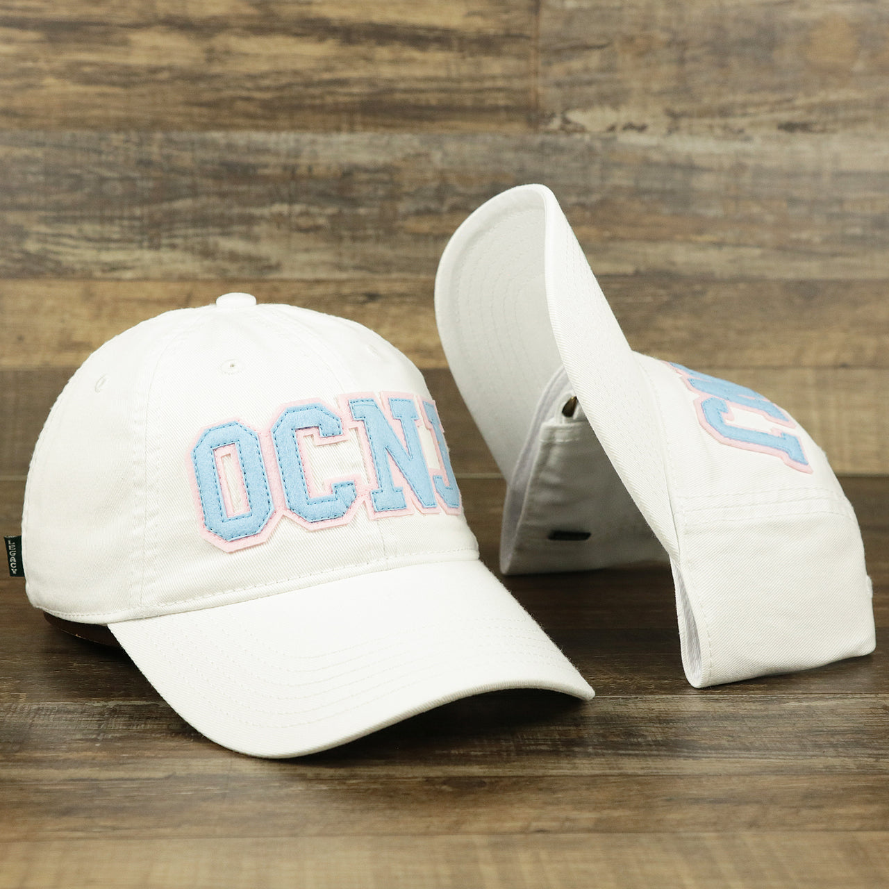 The Youth Light Blue OCNJ Wordmark Pink Outline Dad Hat | Youth White Dad Hat