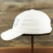 The wearer's left of the Youth Light Blue OCNJ Wordmark Pink Outline Dad Hat | Youth White Dad Hat