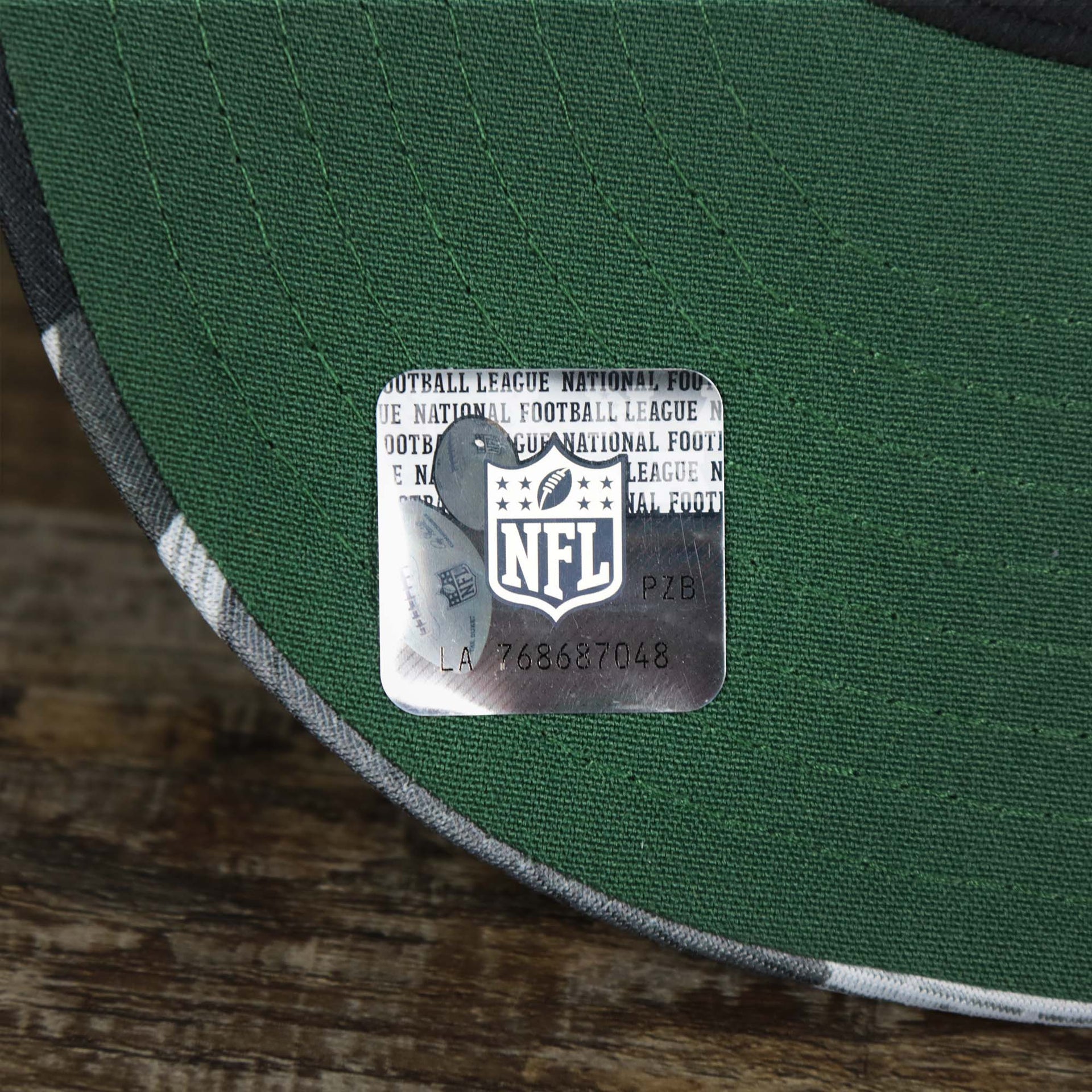 The NFL Sticker on the visor of the Green Bay Packers NFL OnField Summer Training 2022 Camo 9Fifty Snapback | Green Camo 9Fifty