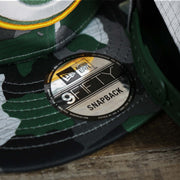 The 9Fifty Sticker on the Green Bay Packers NFL OnField Summer Training 2022 Camo 9Fifty Snapback | Green Camo 9Fifty