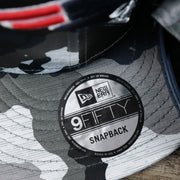 The  9Fifty Sticker on the New England Patriots NFL OnField Summer Training 2022 Camo 9Fifty Snapback | Navy Blue Camo 9Fifty