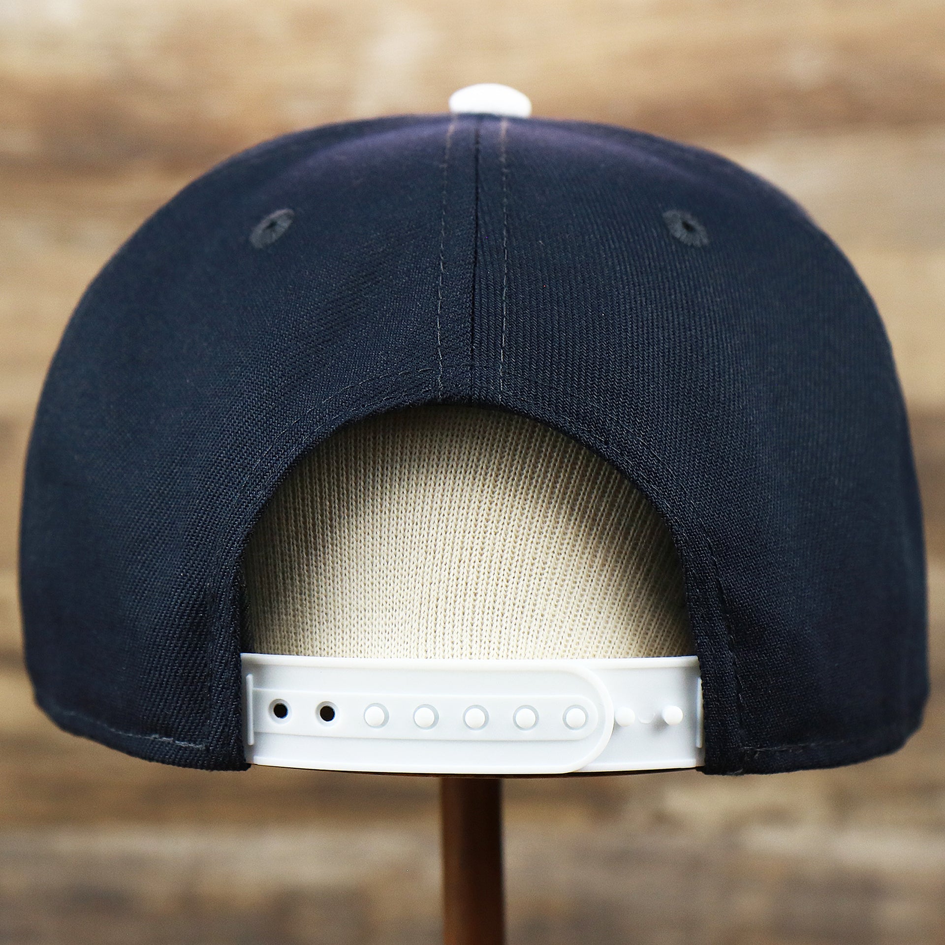 The backside of the Penn State Nittany Lions Team Script Gray Bottom 9Fifty Snapback | Navy Blue And White Snap Cap