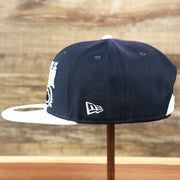 The wearer's left of the Penn State Nittany Lions Team Script Gray Bottom 9Fifty Snapback | Navy Blue And White Snap Cap