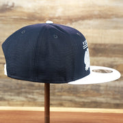 The wearer's right on the Penn State Nittany Lions Team Script Gray Bottom 9Fifty Snapback | Navy Blue And White Snap Cap
