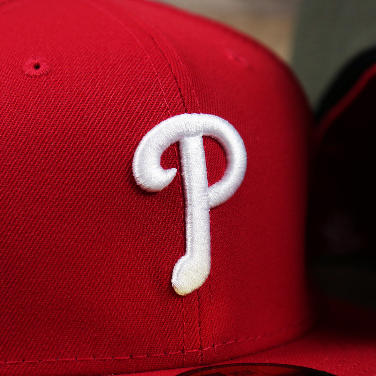 The Phillies Logo on the Philadelphia Phillies Alpha Industries Side Patch Army Green Undervisor 59FIfty Fitted Cap With Hangtag | Red 59FIfty Cap