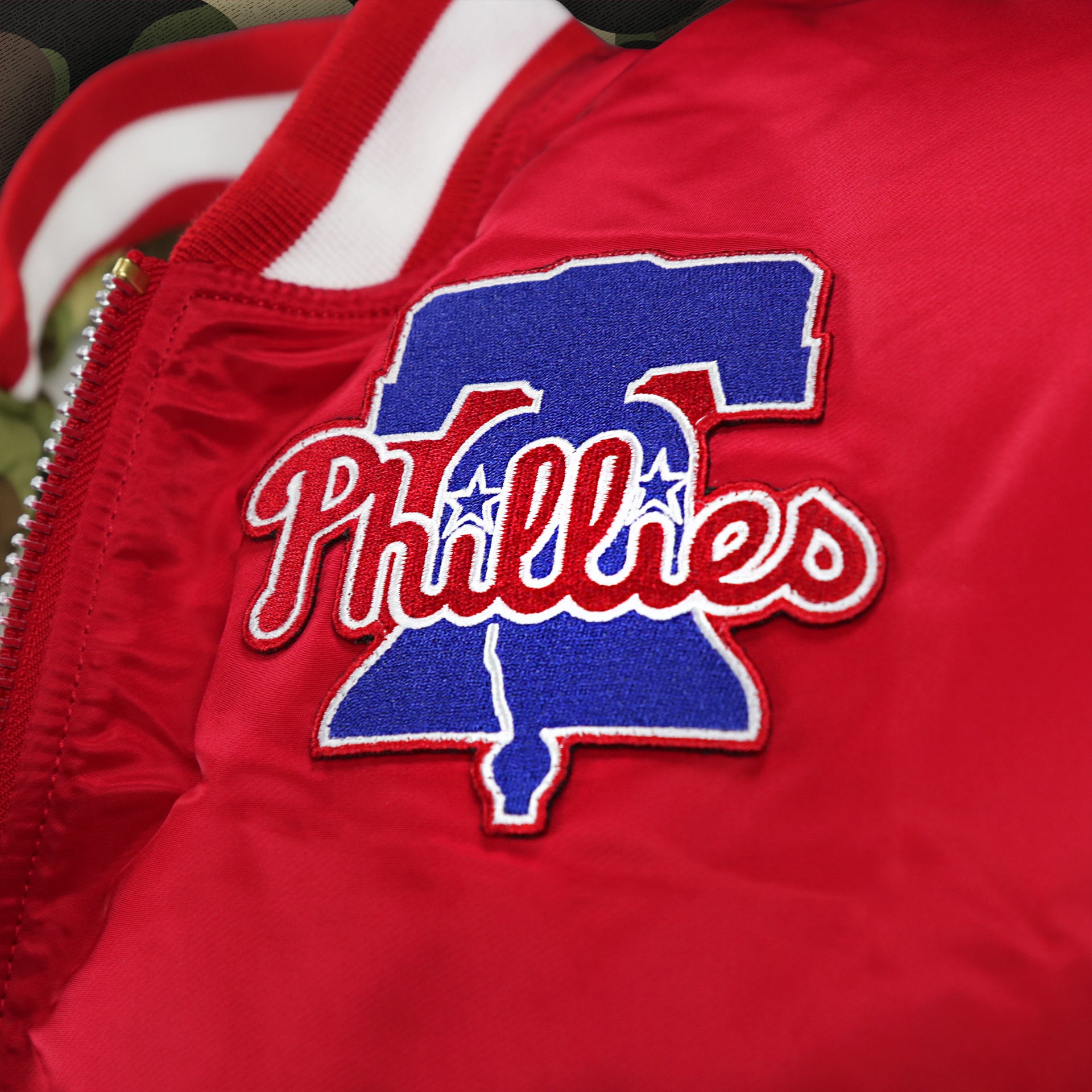 The Phillies Liberty Bell Logo on the Philadelphia Phillies MLB Patch Alpha Industries Reversible Bomber Jacket With Camo Liner | Red Bomber Jacket